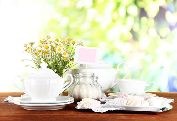 De instelling van de tabel met chamomiles op houten tafel op aard achtergrond — Stockfoto