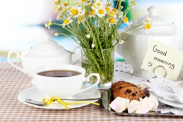 De instelling van de tabel met chamomiles op houten tafel op achtergrond van venster — Stockfoto