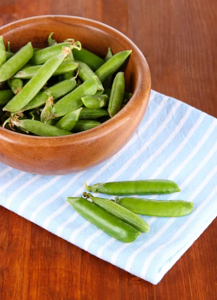 Pois verts dans un bol en bois sur la serviette sur la table — Photo