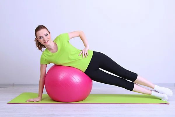 Porträtt av vacker ung kvinna övningar med gym boll — Stockfoto