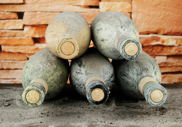 Vieilles bouteilles de vin, sur fond de briques — Photo