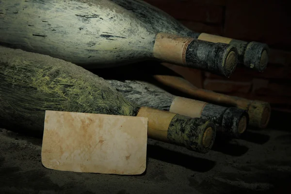 Vieilles bouteilles de vin dans une ancienne cave, sur fond sombre — Photo