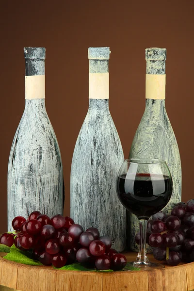 Composition with old bottle of wine and wineglass in old cellar, on dark brown background — Stock Photo, Image