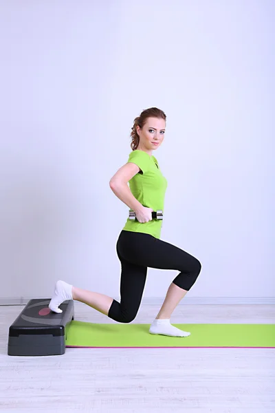 Dumbbell Step üzerine ile güzel bir genç kadın çalışmaları — Stok fotoğraf