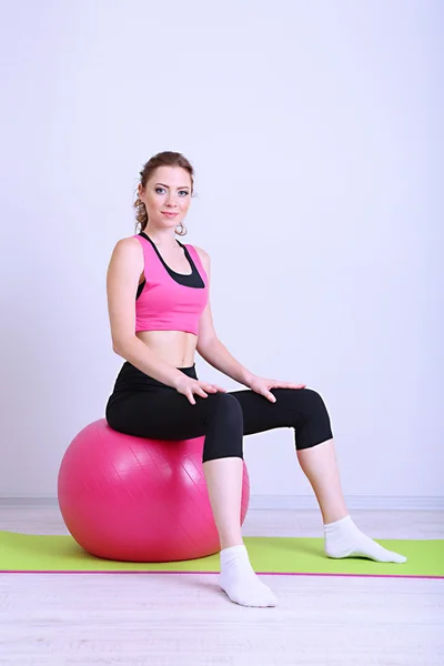 Porträtt av vacker ung kvinna övningar med gym boll — Stockfoto