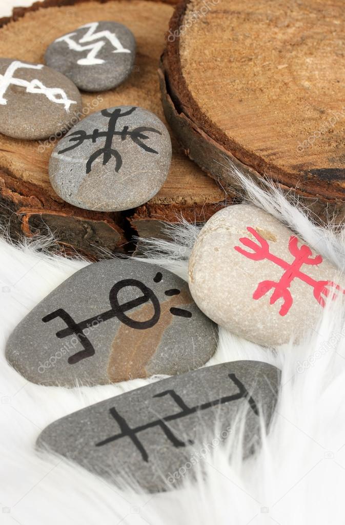 Fortune telling with symbols on stones on white fur background