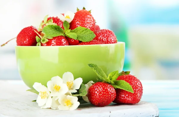 绿色蓝色木桌上的碗里成熟的甜草莓 — 图库照片