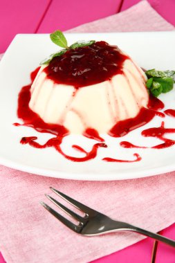 Panna cotta renk ahşap zemin üzerinde frambuaz sos ile
