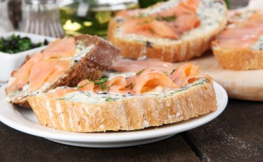 Balık sandviç kesme tahtası ve plaka üzerinde ahşap tablo