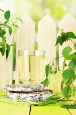 Huş ağacı sap yeşil ahşap masa üzerinde bardak