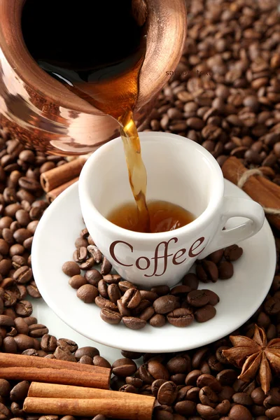 Xícara e panela de café no fundo de grãos de café — Fotografia de Stock