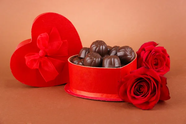 Chocolade snoepjes in de doos van de gift, op bruine achtergrond — Stockfoto