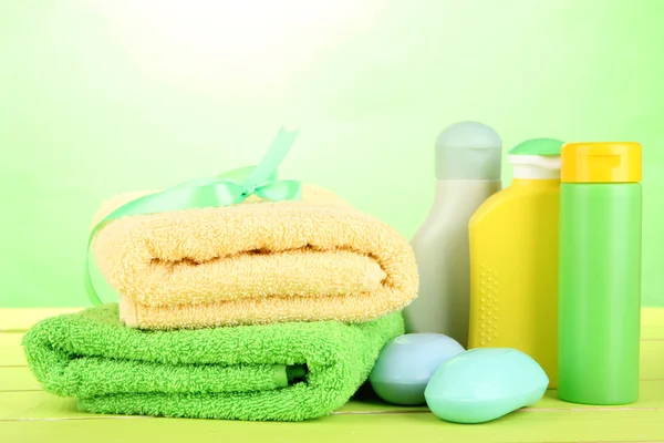 Cosméticos de bebê, sabão e toalhas na mesa de madeira, no fundo verde — Fotografia de Stock