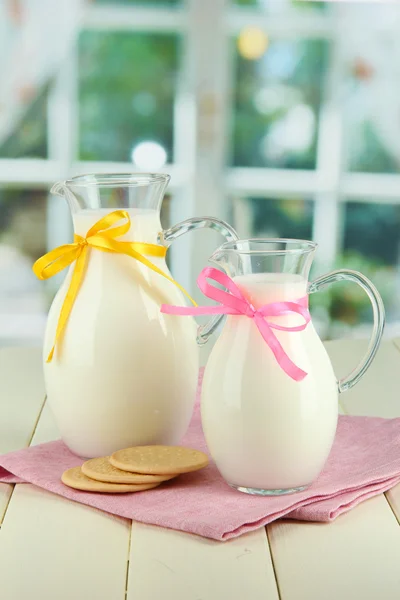 Jarros de leite na mesa no quarto — Fotografia de Stock