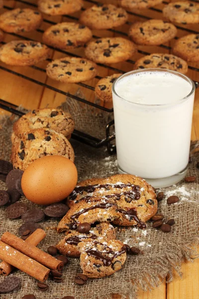 Шоколадное печенье на выпечке со стаканом молока вблизи — стоковое фото