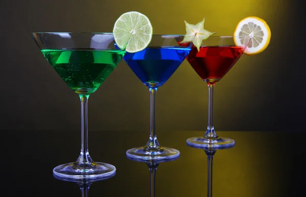 Koyu sarı zemin üzerine martini bardaklarda alkollü kokteyller — Stok fotoğraf