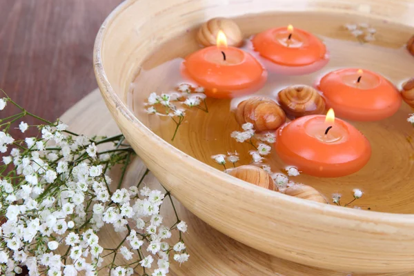 Mooie kaarsen in water op houten tafel close-up — Stockfoto