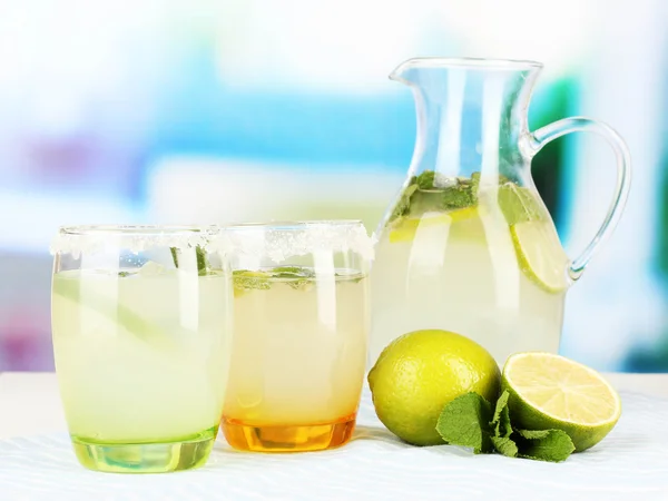 Limonada cítrica en jarra y vasos sobre mesa de madera sobre fondo de habitación —  Fotos de Stock