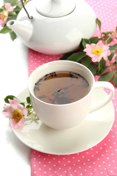 Tasse und Teekanne Kräutertee mit hippen Rosenblüten, isoliert auf weiß — Stockfoto