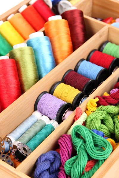 Hilos de colores para la costura en caja de madera de cerca — Foto de Stock