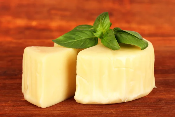 Mozzarella sajt és a bazsalikom a fából készült háttér — Stock Fotó
