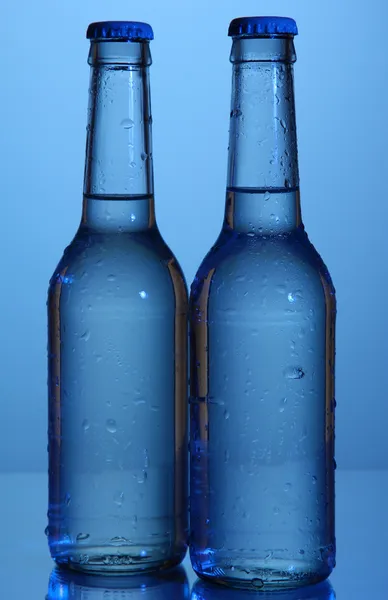 Botellas de agua sobre fondo azul —  Fotos de Stock