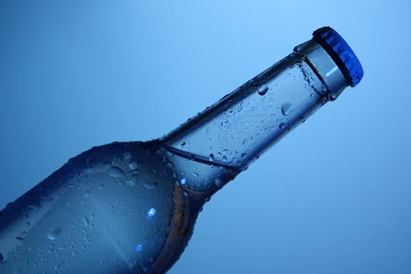 Бутылка воды на голубом фоне — стоковое фото