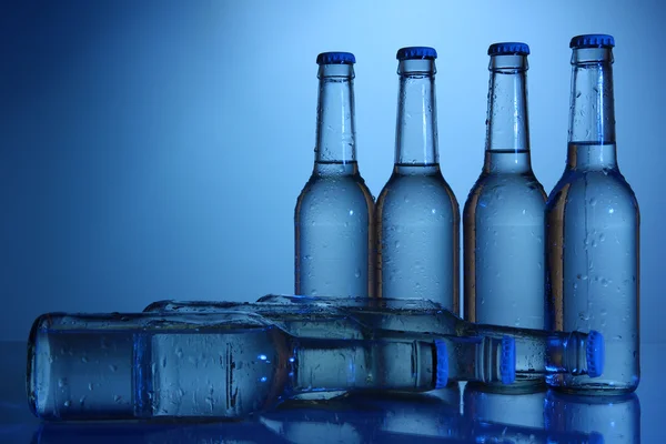 Botellas de agua sobre fondo azul — Foto de Stock