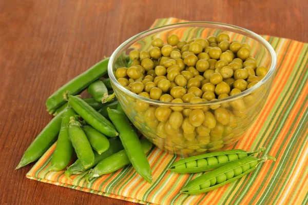 Guisantes verdes sobre fondo de madera — Foto de Stock