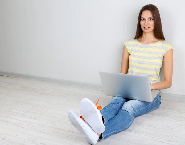Mulher bonita sentada com laptop no quarto — Fotografia de Stock