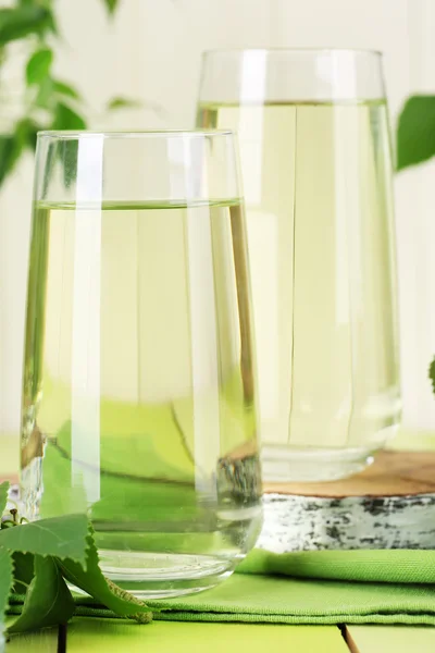 Gläser Birkensaft auf grünem Holztisch — Stockfoto