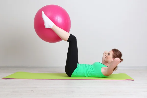 Portrait of beautiful young woman exercises with gym ball — Stock Photo, Image