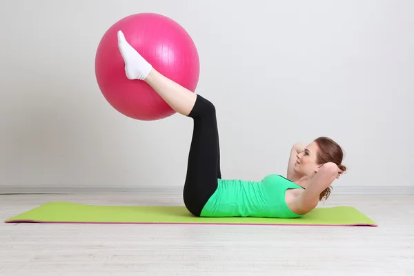 Porträtt av vacker ung kvinna övningar med gym boll — Stockfoto