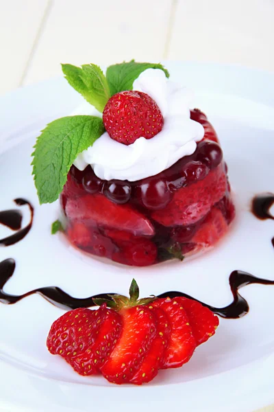 Tasty jelly dessert with fresh berries, on color wooden background — Stock Photo, Image