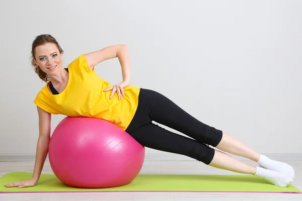 Portret van mooie jonge vrouw oefeningen met gymnastiek bal — Stockfoto