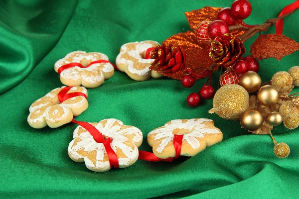 Weihnachtsplätzchen und Dekorationen auf farbigem Stoff Hintergrund — Stockfoto