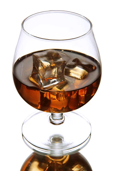 Brandy glass with ice on grey background — Stock Photo, Image