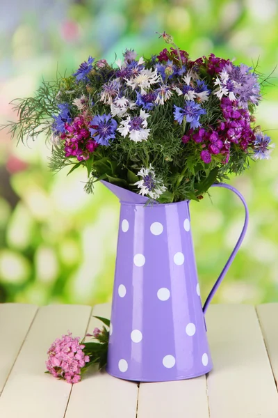 Beau bouquet en pichet sur table en bois sur fond naturel — Photo