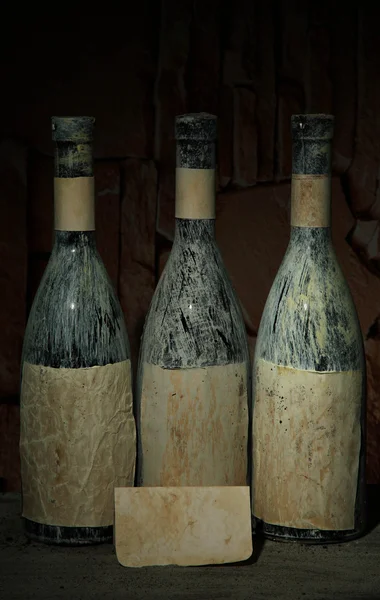 Viejas botellas de vino en bodega vieja, sobre fondo oscuro —  Fotos de Stock