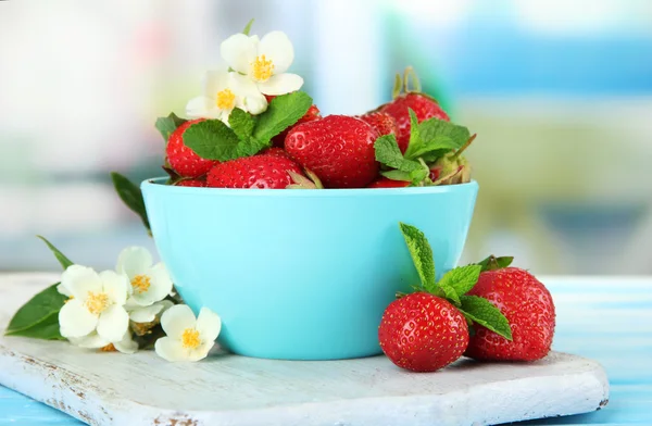 Ώριμα γλυκό φράουλες σε μπολ στο μπλε ξύλινο τραπέζι — Φωτογραφία Αρχείου
