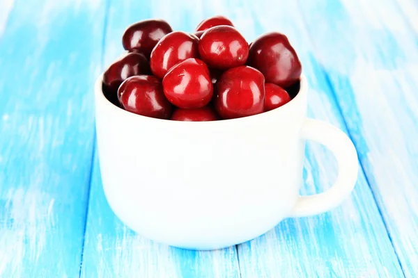 Kirschbeeren im Becher auf Holztisch in Großaufnahme — Stockfoto