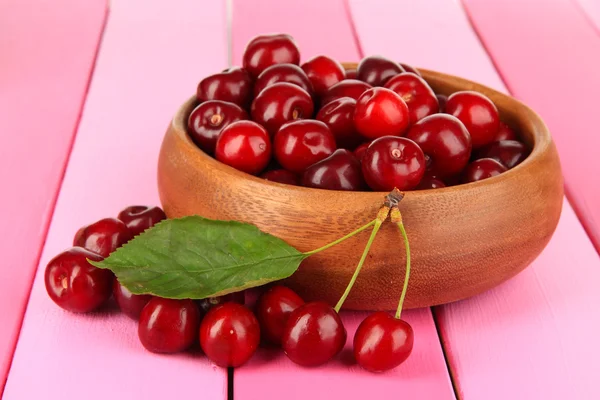 Cherry berries in bowl on wooden table close-up — Stock Photo, Image