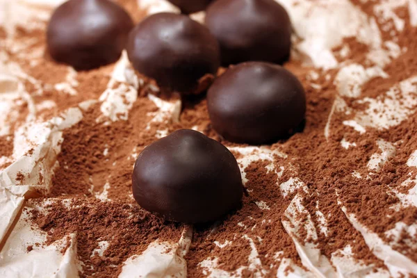 Doces de chocolate com cacau em pó, close-up — Fotografia de Stock