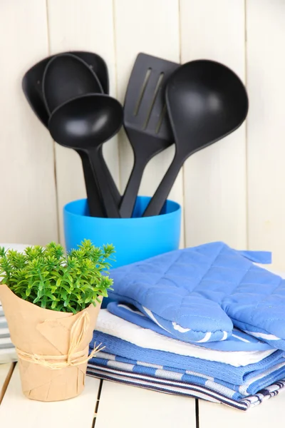 Ajustes de cocina: utensilios, agarraderas, toallas y más en la mesa de madera —  Fotos de Stock