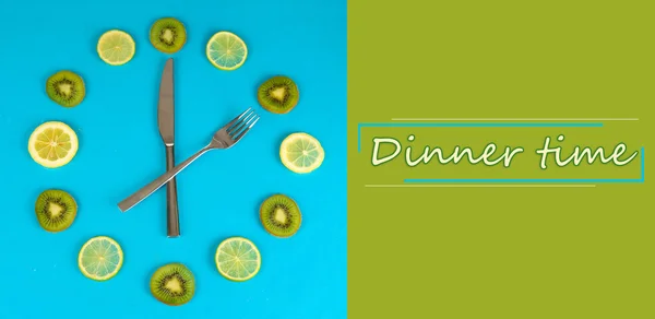Klocka gjord av kiwi, lime och citron skivor, på färgbakgrund — Stockfoto