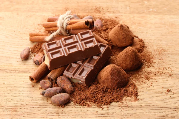 Composición de dulces de chocolate, cacao y especias sobre fondo de madera — Foto de Stock