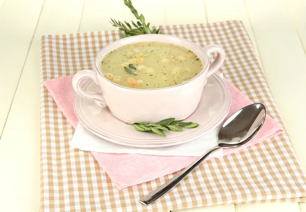 Nourishing soup in pink pan on wooden table close-up — Stock Photo, Image