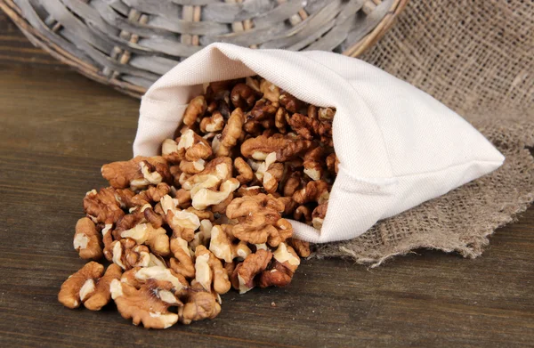 Nuts in sack on wooden background — Stock Photo, Image