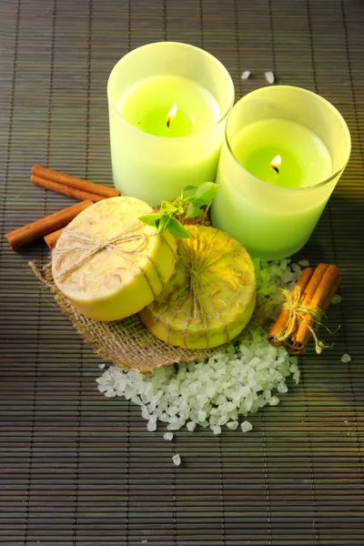 Sapone fatto a mano e candele su sfondo tappetino di bambù — Foto Stock