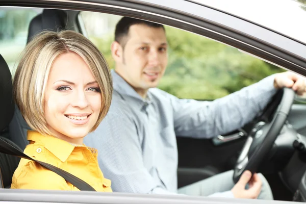 Porträtt av unga vackra paret sitter i bilen — Stockfoto